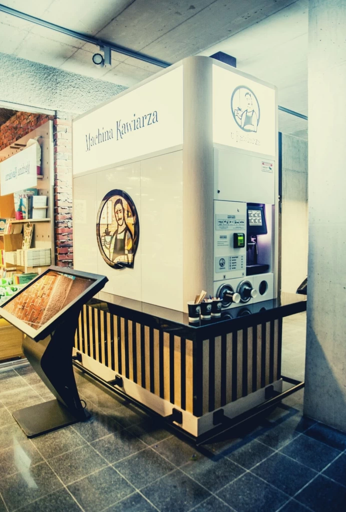 Machina kawiarza, jako profesjonalny automat z kawą połączony z miejscem na spokojne wypicie kupionego napoju. Nowoczesna forma kawiarni.